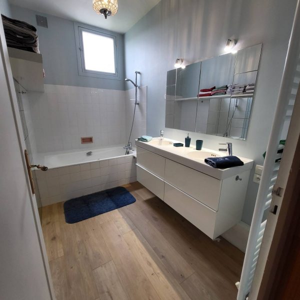 Salle de bains moderne et bien équipée du Gîte L'Intemporelle, avec douche, lavabo et rangements.