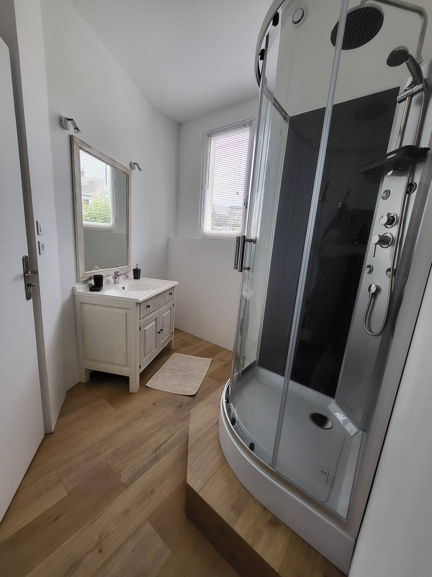Salle de bains moderne et bien équipée du Gîte L'Intemporelle, avec douche, lavabo et rangements.